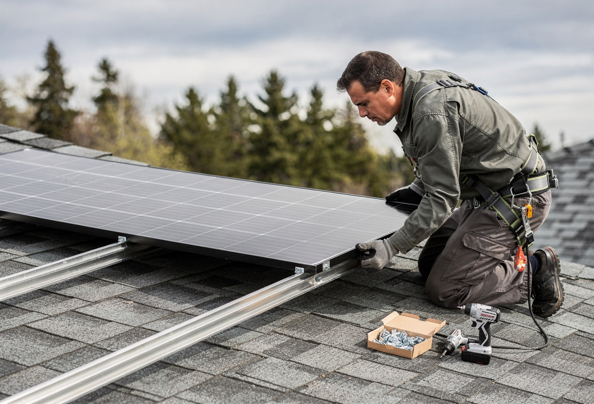 Certified technician fastening a solar panel onto a residential roof rail